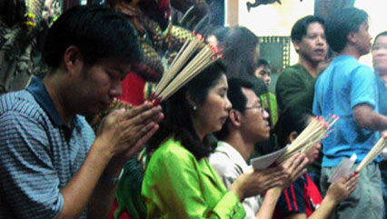 Thaïlandais priant dans un temple chinois de Bangkok